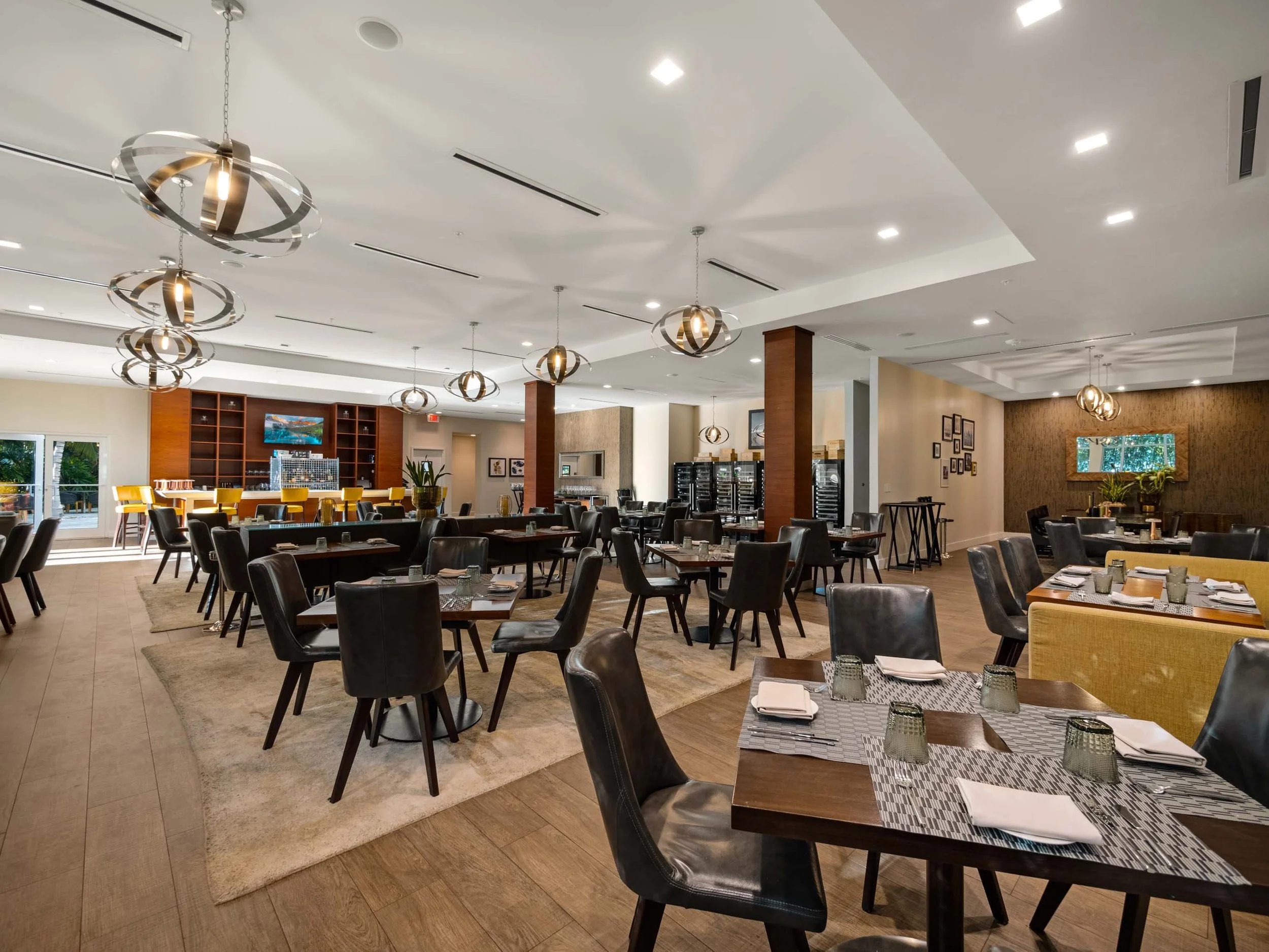 Restaurant at The Ritz-Carlton, Turks and Caicos, with dining tables, wood finishes, and sculptural lights.
