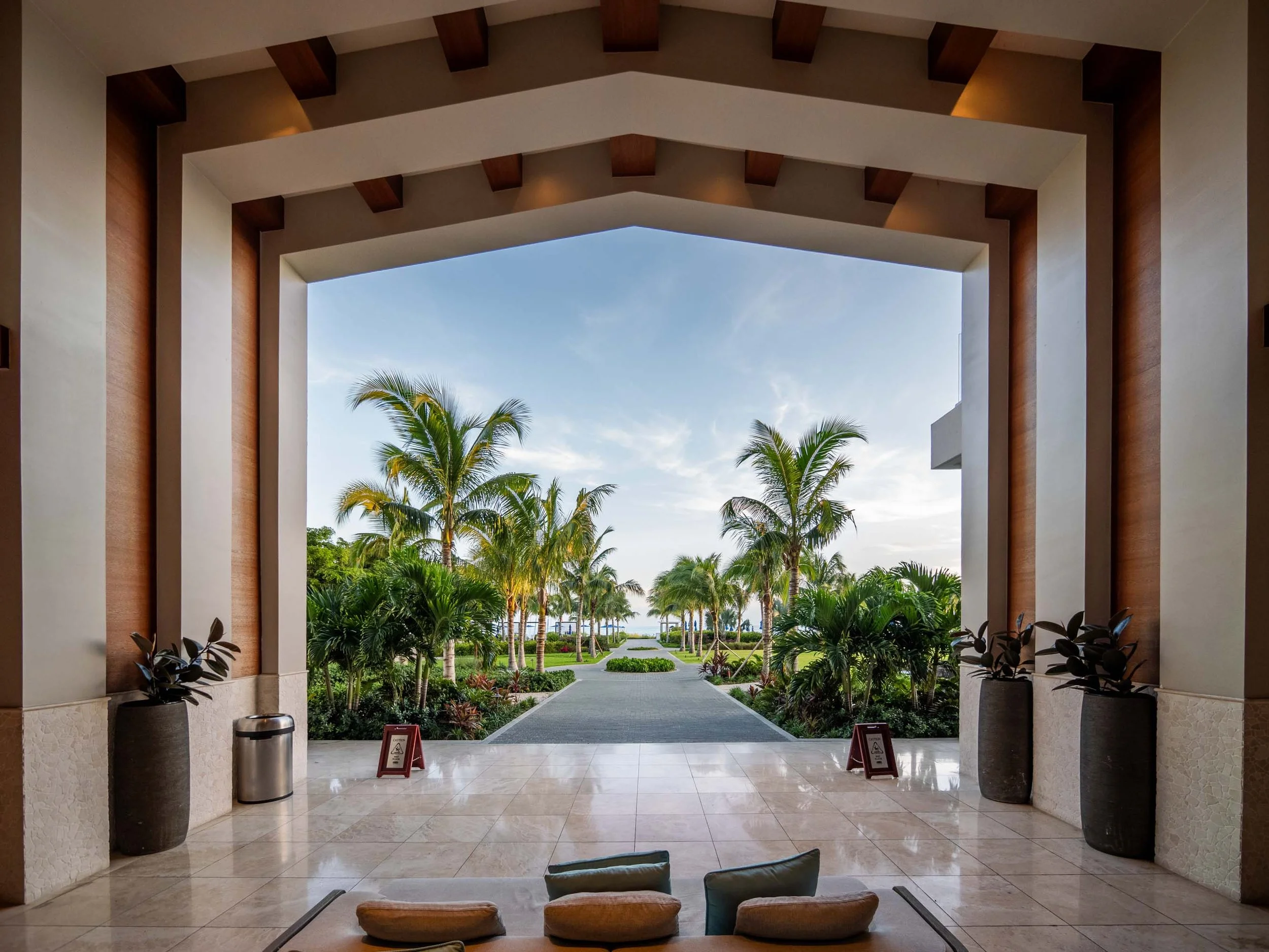 Open-air lobby at The Ritz-Carlton, Turks and Caicos, framing a garden path toward the ocean.