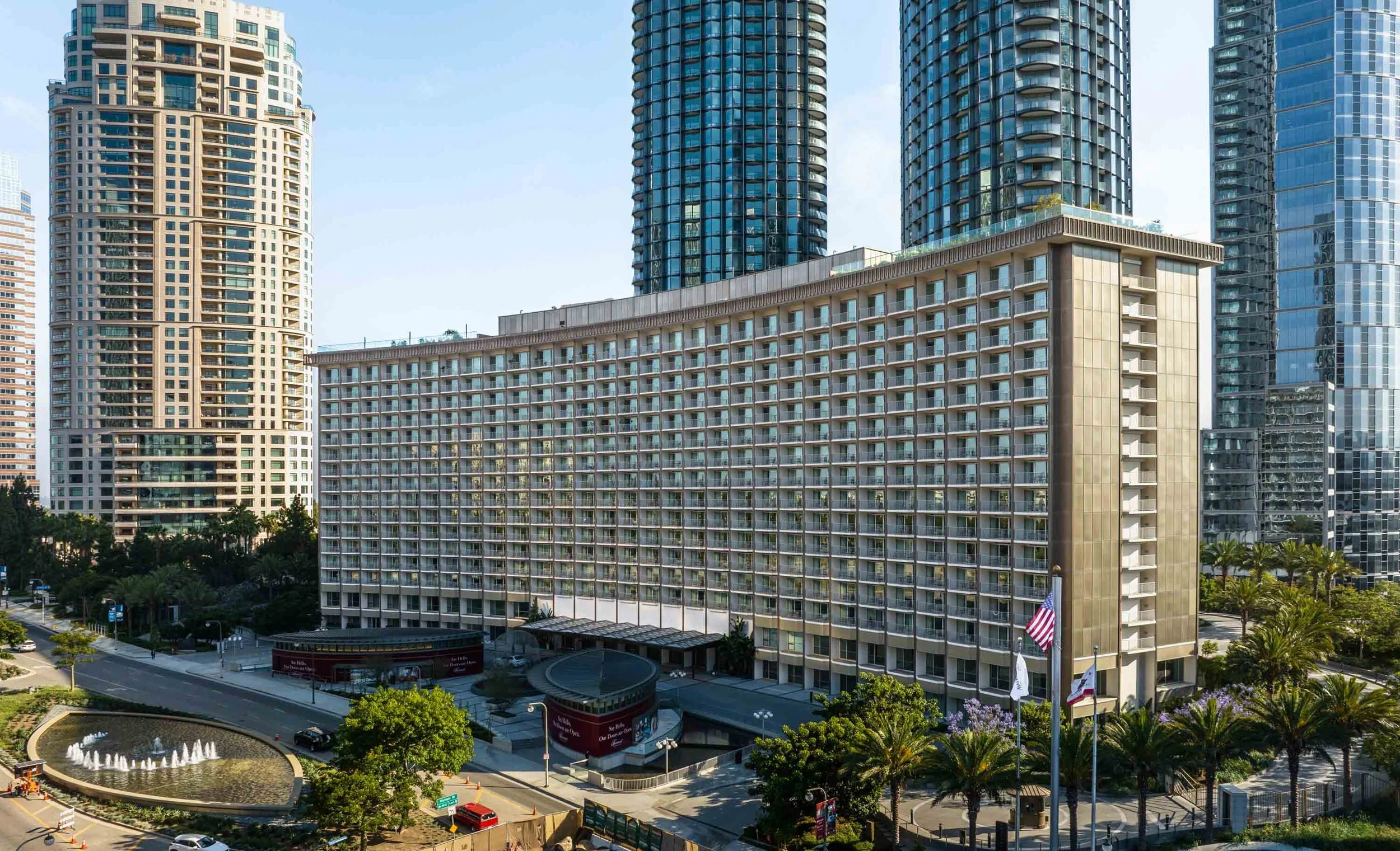 Fairmont Century Plaza facade and entrance court in daylight with surrounding high-rise towers.