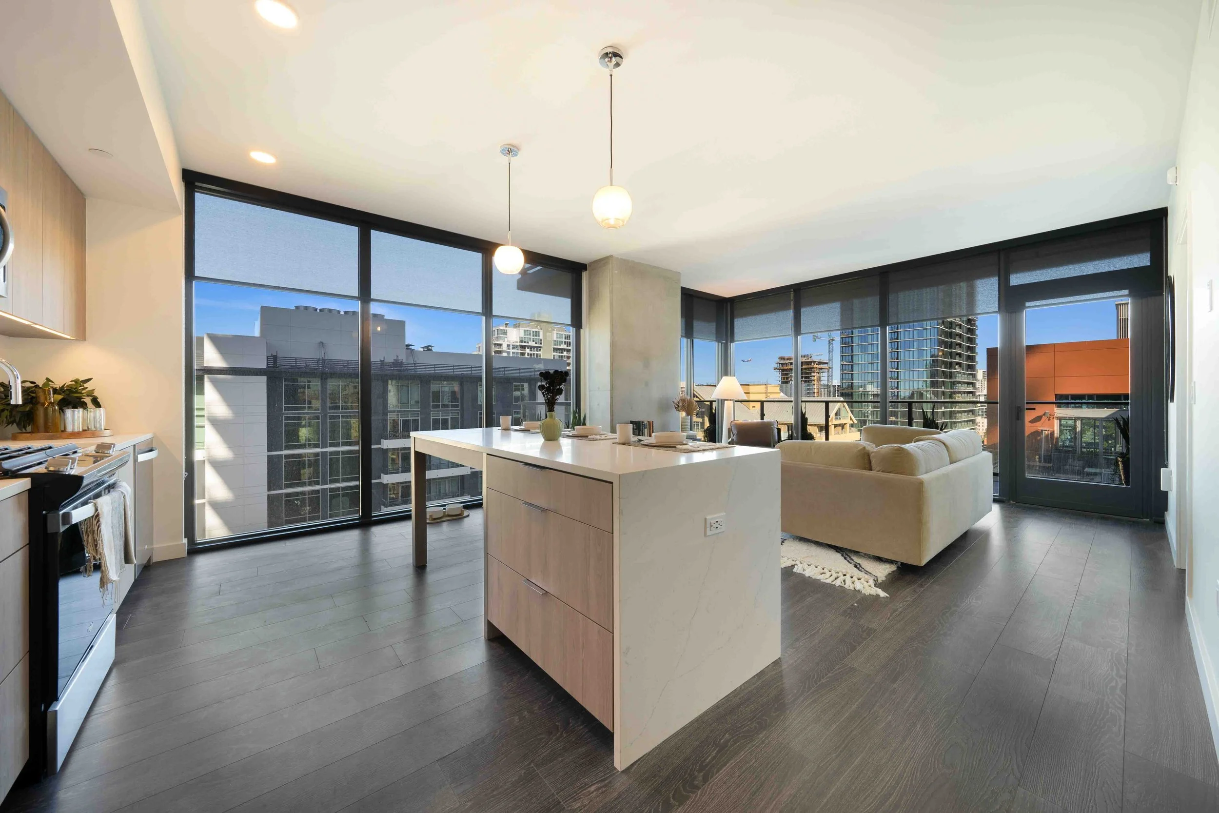 Open kitchen and living area at The Lindley with a white island and large windows.