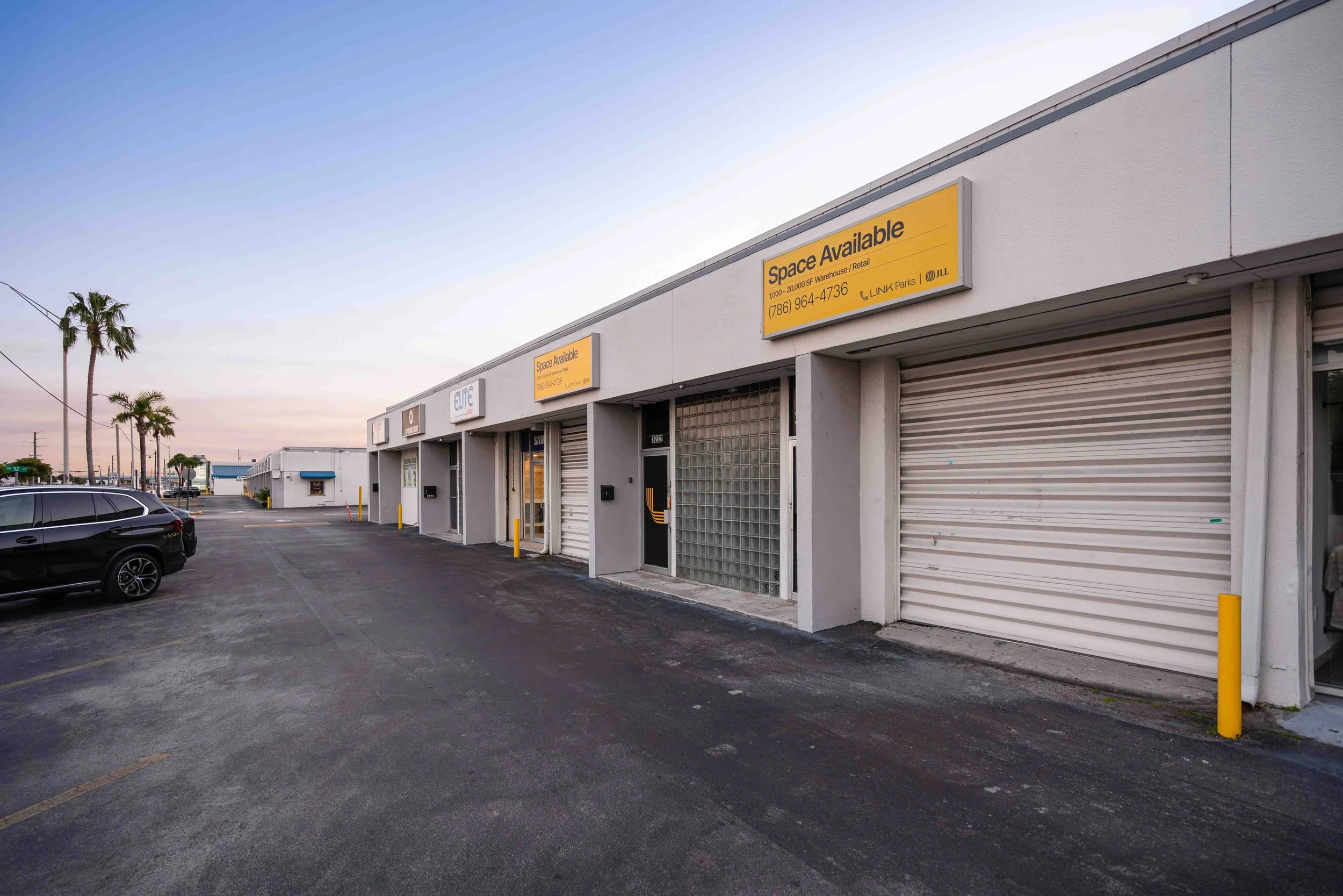 Airport Trade Center flex units with roll-up doors, pedestrian entrances, and palm trees.