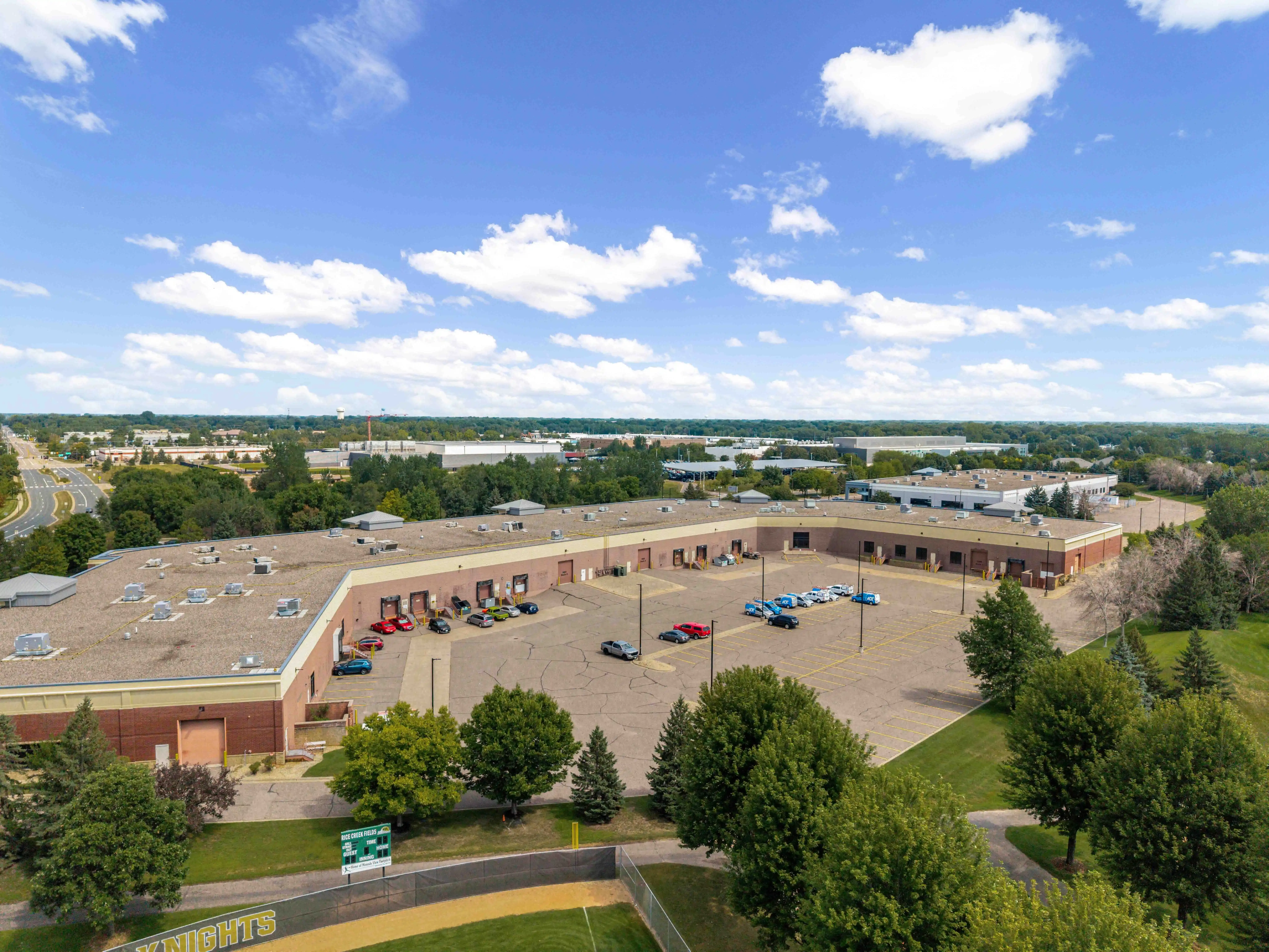 Aerial view of Rice Creek Business Center I showing the building, parking, and surrounding trees.