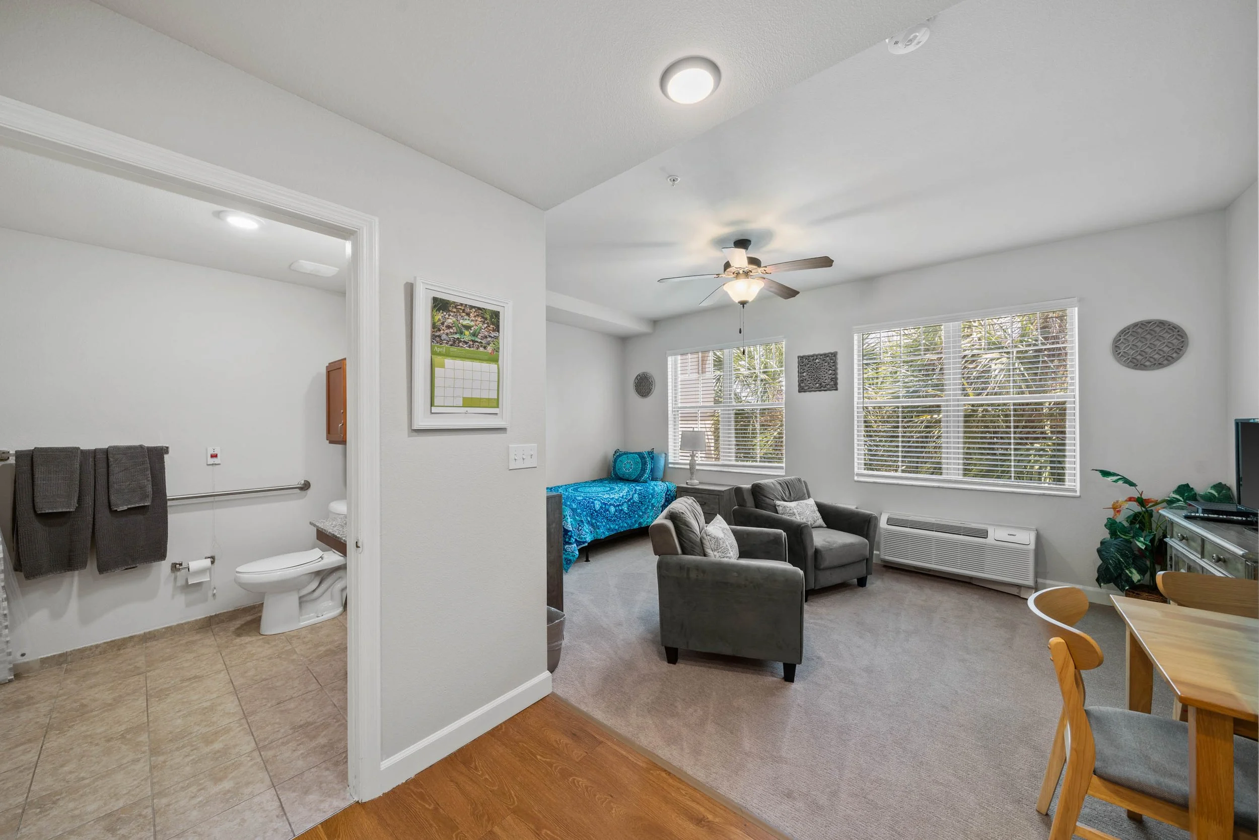 Residential suite at The Glades at ChampionsGate with a sitting area, dining table, and adjoining bathroom.