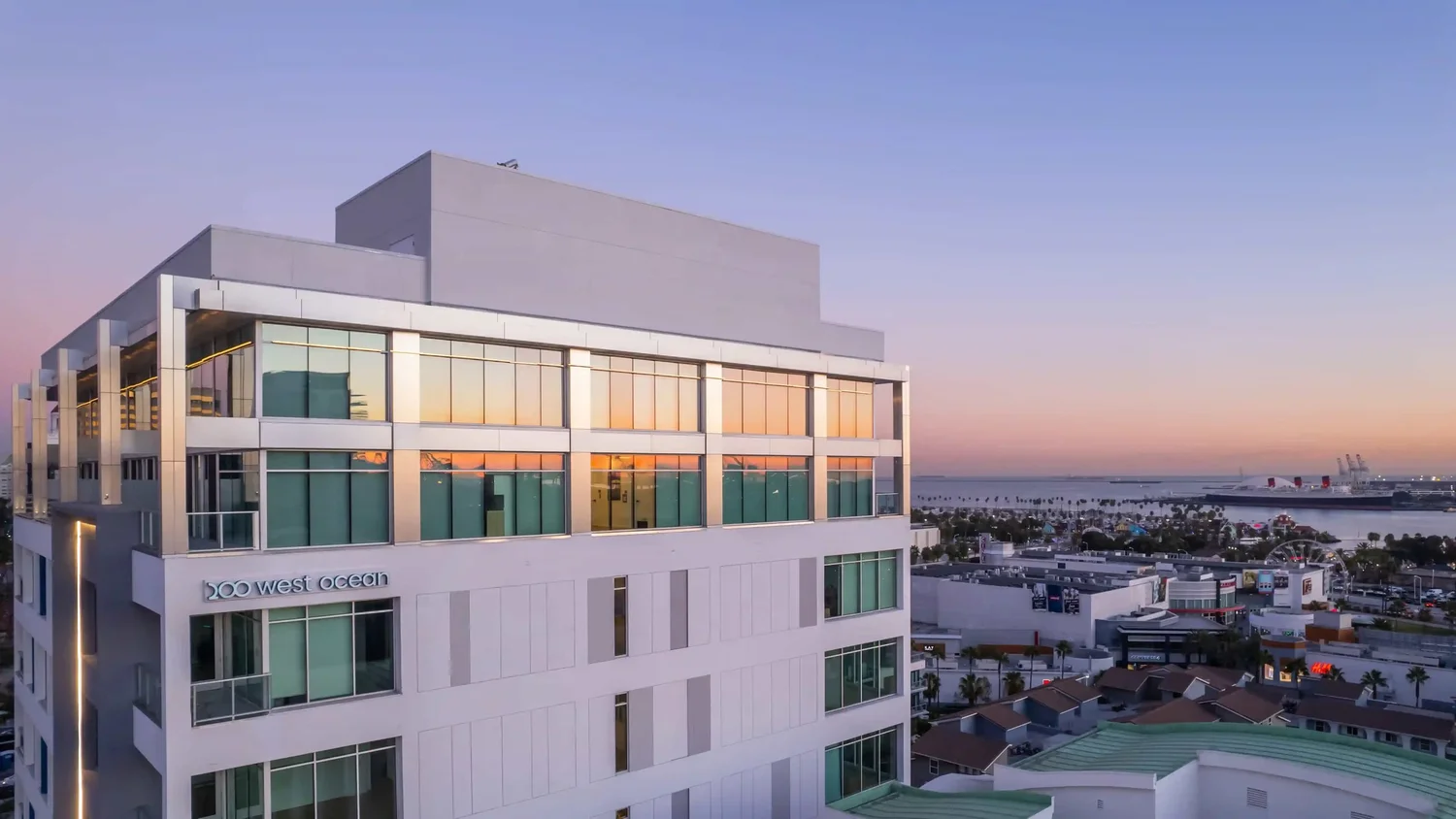 White residential building with waterfront surroundings seen in early evening light