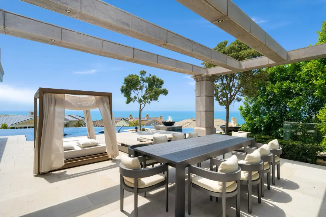 Outdoor dining terrace with ocean view, pergola, dining chairs and lounge seating