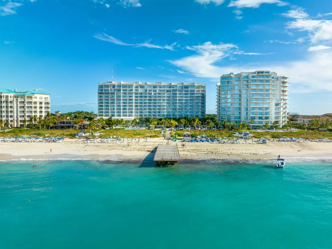 Coastal hospitality buildings photographed from above with beach and waterfront visible